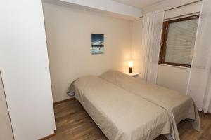 a small bedroom with a bed and a window at Cozy Alpine-Style Apartment in the Heart of Levi with Private Sauna & Fireplace in Levi