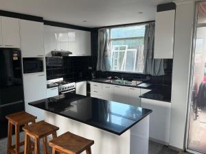 a kitchen with white cabinets and a black counter top at SBs Apartment-1 in Suva