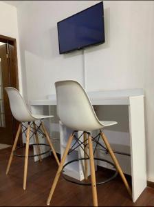 2 sedie e un tavolo con tv a muro di Departamento Moderno y Centrico check in autonomo no necesitas llaves a Guaymas