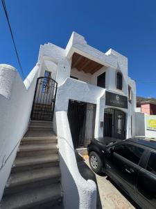 una macchina nera parcheggiata di fronte a una casa bianca di Departamento Moderno y Centrico check in autonomo no necesitas llaves a Guaymas