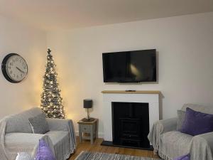 een woonkamer met een kerstboom en een open haard bij The Howff in Anstruther