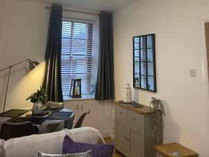 een woonkamer met een tafel en een raam bij The Howff in Anstruther