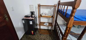 een slaapzaal met een koelkast en een stapelbed bij Suíte Trilha do Sol 2 in Arraial do Cabo