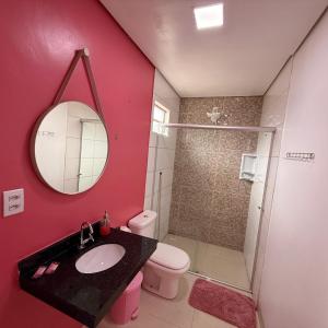 a bathroom with a sink and a toilet and a mirror at Family Space - Chacara Rosa Beautiful and Comfortable in Cuiabá