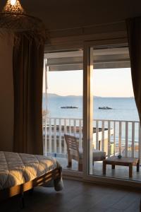 a bedroom with a view of the ocean from a balcony at Life House B&B in Follonica