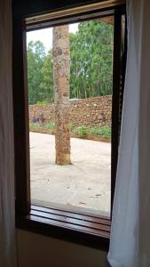 a window with a view of a stone pillar at Vinhas das Grutas in Soledade