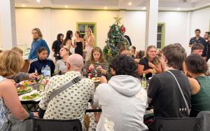 琅勃拉邦White Elephant Hostel的一群人坐在圣诞树前的桌子旁。 更多48张照片