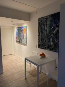 a room with a table and two paintings on the wall at Lake view, private balcony in Skanderborg