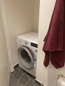 a washing machine in a bathroom with a towel at Lake view, private balcony in Skanderborg