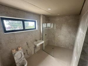 a bathroom with a toilet and a shower and a sink at SBs Apartment-1 in Suva