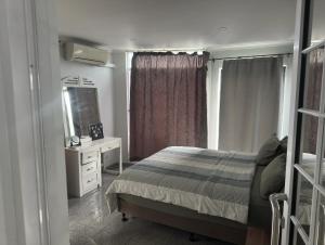 a bedroom with a bed and a dresser and a mirror at SBs Apartment-1 in Suva +5 photos