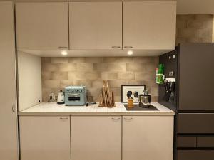 a kitchen with white cabinets and a stove and a refrigerator at 金春 -in KONPAL Penthouse- in Kikuyo