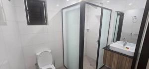 a bathroom with a shower and a toilet and a sink at The Retreat Apartment in Nadi +21 photos