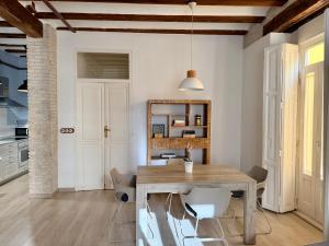 een keuken en eetkamer met een houten tafel en stoelen bij Teixidors de Palomar - PalomarGroup in Valencia