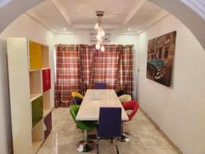 una sala da pranzo con tavolo e sedie colorate di S J Lodge  Altre 3 foto