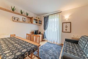 een woonkamer met een bed en een tafel bij Dolomites Essence in Falcade