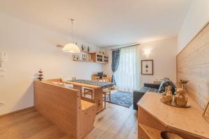 een woonkamer met een keuken en een eetkamer bij Dolomites Essence in Falcade