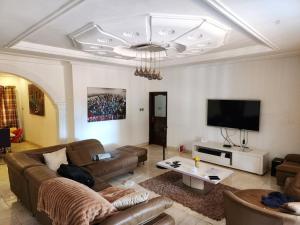 un soggiorno con divano e TV a schermo piatto di S J Lodge 