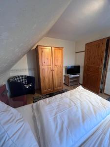 a bedroom with a bed and wooden cabinets and a tv at Ferienwohnung für Handwerker in Kappeln