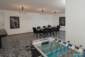 a ping pong table in a room with a table and chairs at Don Leon Boutique in Even Menahem