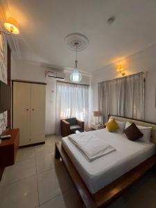 een slaapkamer met een groot wit bed en een bureau bij Trevors Home Place in Lagos