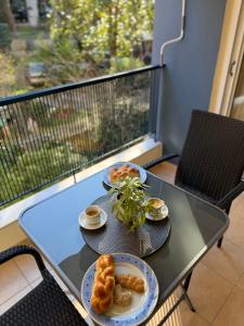 a table with two plates of food on a balcony at The Allatini project Thessaloniki- Part of P STAYS COLLECTION in Thessaloniki
