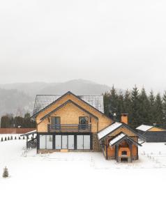 a house in the snow with snow on it at Meștera 9 in Stînceni