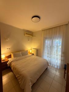 a bedroom with a large white bed and a window at The Allatini project Thessaloniki- Part of P STAYS COLLECTION in Thessaloniki