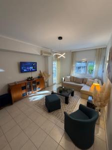 a living room with a couch and a tv at The Allatini project Thessaloniki- Part of P STAYS COLLECTION in Thessaloniki