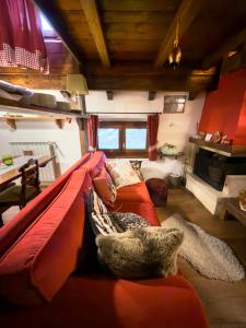 a living room with a red couch and a table at CasaVacanze Roccaraso in Roccaraso