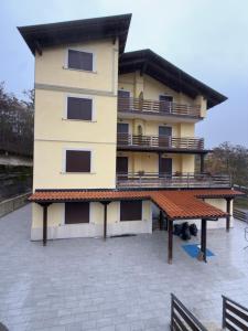 a large yellow building with a large deck at CasaVacanze Roccaraso in Roccaraso