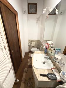 a bathroom with a sink and a toilet and a mirror at CasaVacanze Roccaraso in Roccaraso