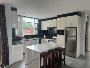 a kitchen with white cabinets and a refrigerator and a counter at SBs Apartment-1 in Suva