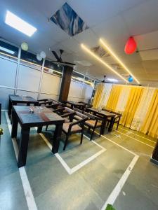 een rij tafels in een kamer met gele gordijnen bij Staylo master Inn Near Max Hospital in Lucknow