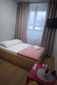 a bedroom with a bed and a window and a table at Sami Swoi Kutno in Kutno +31 photos