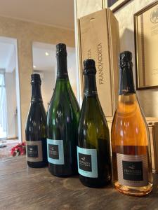 drie flessen wijn bovenop een tafel bij Hotel Marchina in Brescia