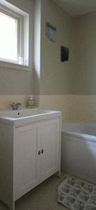 a bathroom with a sink and a tub and a window at Dunslair View Appartment in Peebles +12 photos