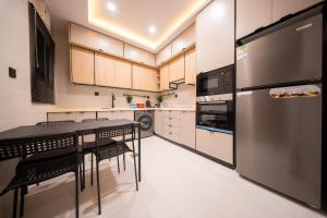 a kitchen with a table and a refrigerator at Revana for families in Jeddah