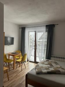 a bedroom with a bed and a table and chairs at Willa Agma in Zakopane