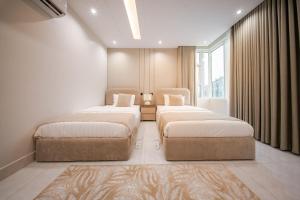 a bedroom with two beds and a window at Revana for families in Jeddah
