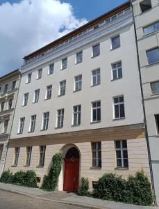 a large white building with a red door at Studio Berlin Center in Berlin