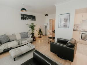 a living room with a couch and two chairs at 5 Mariners Wharf in Newhaven