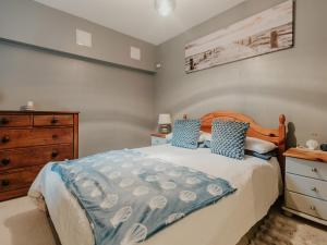a bedroom with a bed with a wooden headboard and a dresser at 5 Mariners Wharf in Newhaven