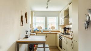 een kleine keuken met een houten tafel bij Wee Jules By The Sea in Cellardyke