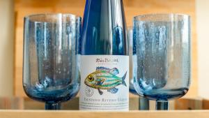 een fles wijn naast twee wijnglazen bij Wee Jules By The Sea in Cellardyke