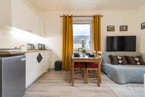 a small kitchen with a table and a couch at Za radnicí 2 & 5 by Mountain ways in Rokytnice nad Jizerou