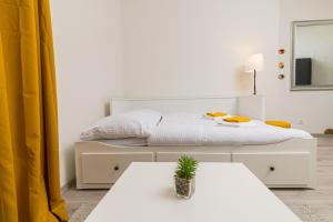 a white bedroom with a bed and a table at Za radnicí 2 & 5 by Mountain ways in Rokytnice nad Jizerou
