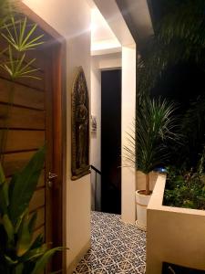een hal met een deur en potplanten bij Kitya Homestay in Phumĭ Ta Phŭl
