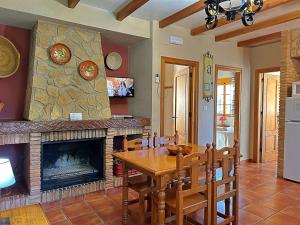 une salle à manger avec une table et une cheminée dans l'établissement Casa Laguna del Maiz cazorla, à Burunchel