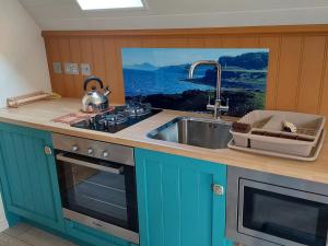 een keuken met een wastafel, een fornuis en een wastafel bij Bonnie Wee Neuk in Arbuthnott +17 foto's